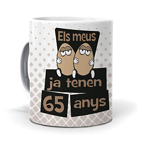 Consigue ahora Mundohuevo Taza Regalo Regalos 65 cumpleaños Hombre en Catalan ELS meus Ous ja tenen 65 anys. Ceramica AAA - 350 ml. Ofertas 2025 | regaloscumple.com